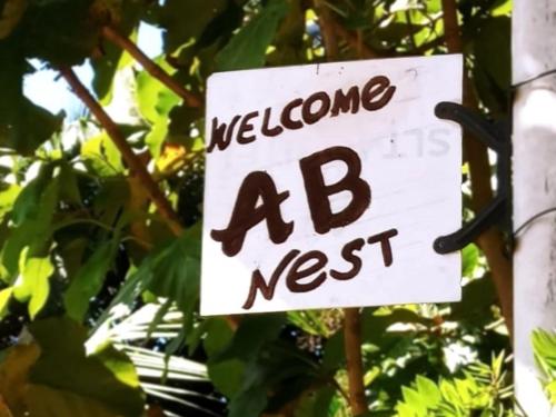 a sign that says welcome ad next to a tree at AB Nest Hiriketiya in Dickwella