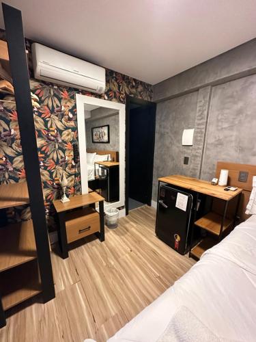 1 dormitorio con cama, escritorio y espejo en Hotel La Serena, en Maresias