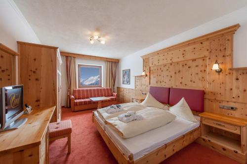 een hotelkamer met een bed en een televisie bij SKI - GOLF - WELLNESS Hotel Riml in Hochgurgl
