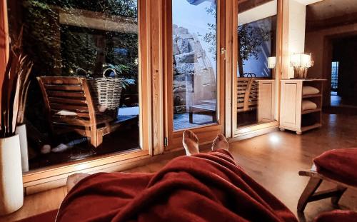 a person laying on a bed in a room with windows at Landhaus Talblick- Frühstückspension in Brotterode-Trusetal