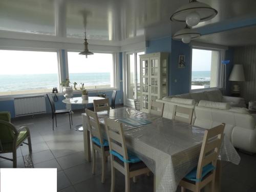 une salle à manger et un salon avec une table et des chaises dans l'établissement Villa Face Mer, à Audresselles