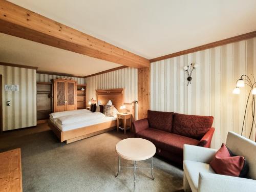 a hotel room with a bed and a couch at Landhaus Talblick- Boutique B&B-Pension-Gästehaus in Brotterode-Trusetal