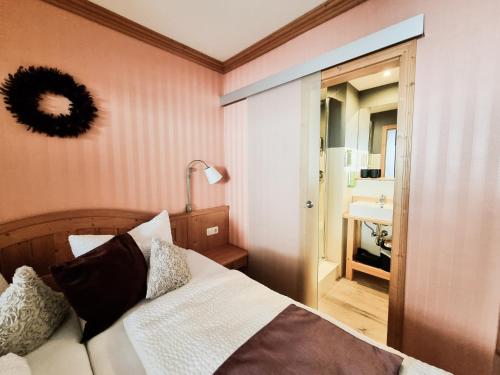 a bedroom with a bed and a bathroom with a sink at Landhaus Talblick- Frühstückspension in Brotterode-Trusetal