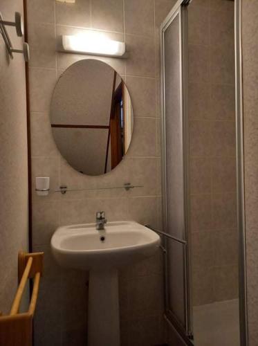 une salle de bain avec un lavabo et un miroir dans l'établissement Villa d'angle spacieuse climatisée étage, clôturée dans domaine PORTES DU SOLEIL, 3 chambres, 7 couchages, wifi, accès payant aux piscines, 400m de la mer de portiragnes plage,LRPDSR6, à Portiragnes