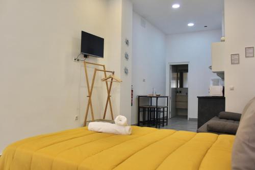 Un dormitorio con una cama amarilla con una toalla. en NUEVO ESTUDIO DIVINA PASTORA N-1, en Málaga