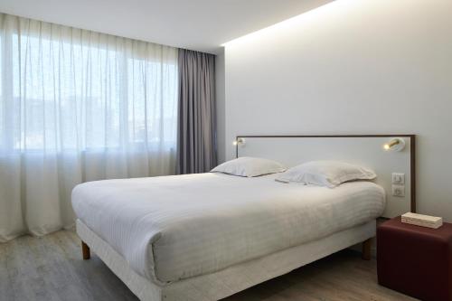 Кровать или кровати в номере Hotel-Restaurant Isidore Nice Ouest