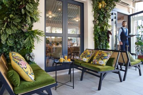 - un hall avec deux chaises, une table et un costume dans l'établissement Hotel-Restaurant Isidore Nice Ouest, à Nice