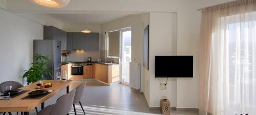 a kitchen and dining room with a table and a television at Elia Hotel Residence in Budva