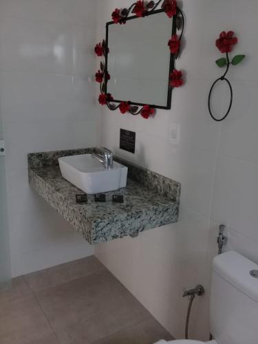 a bathroom with a sink and a mirror on the wall at Hotel Pousada Riacho da Areia in Águas de Lindóia