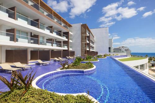 an external view of a hotel with a swimming pool at Royalton Splash Riviera Cancun, An Autograph Collection All-Inclusive Resort in Cancún