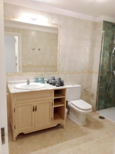 a bathroom with a sink and a toilet and a mirror at Casa Paraiso in Los Cristianos