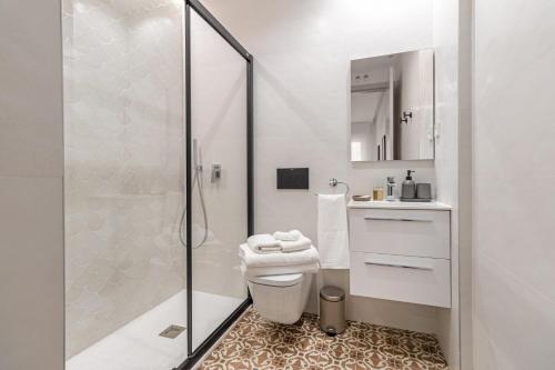 a white bathroom with a shower and a toilet at Apartamento para 4 en Chamberi Quevedo V in Madrid