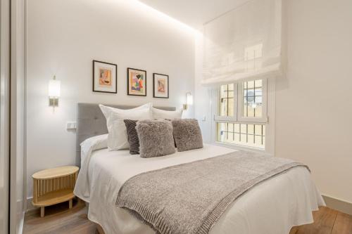 um quarto branco com uma cama e uma janela em Apartamento para 2 en Chamberi Quevedo IV em Madrid