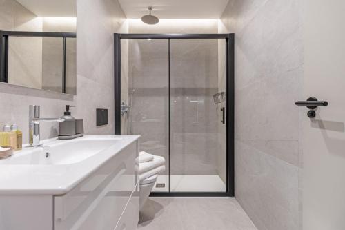 uma casa de banho branca com um chuveiro e um lavatório. em Apartamento para 2 en Chamberi Quevedo IV em Madrid