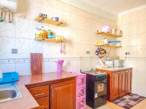 a kitchen with a sink and a stove in it at Fefe's home in Dar es Salaam