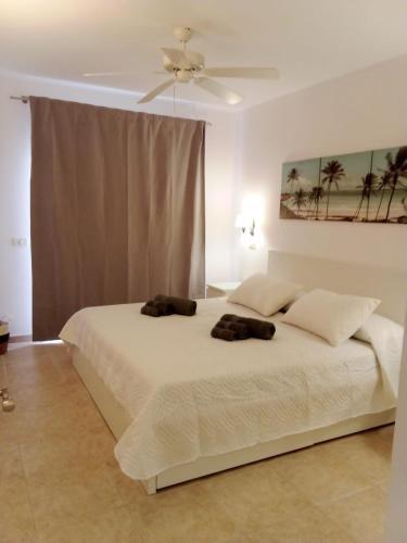 a bedroom with a large white bed with two pillows at Casa Paraiso in Los Cristianos