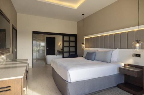 a bedroom with a large bed and a bathroom at Royalton Hideaway Blue Waters, An Autograph Collection All-Inclusive Resort - Adults Only in Falmouth