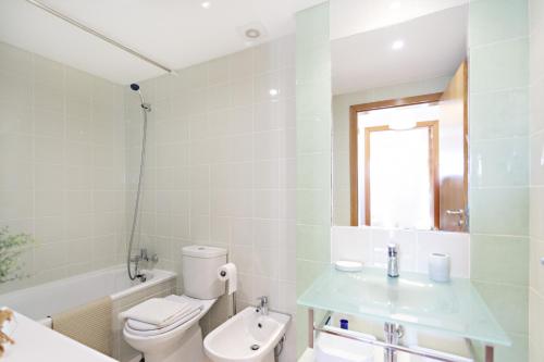 a bathroom with a toilet and a sink and a tub at Formosa Bay by MY CHOICE in Cabanas de Tavira