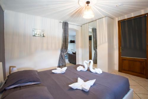 Un dormitorio con una cama con toallas blancas. en Le Cocon appart avec parking privé & terrasse, en Sainte-Croix-en-Plaine
