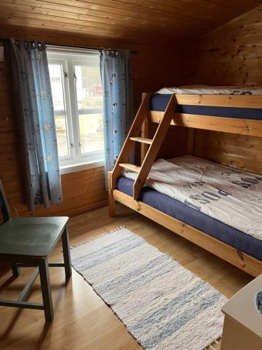 a bedroom with two bunk beds and a window at Naustplassen Rorbuer in Ballstad