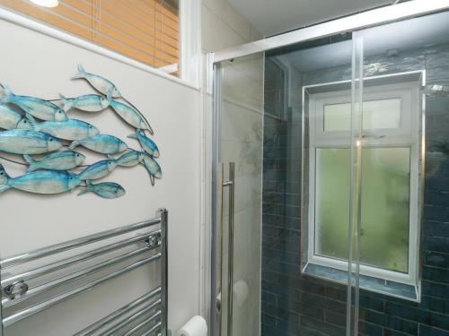 uma casa de banho com uma cabina de duche em vidro e um mural de golfinhos em 6 Hillside Terrace em Dartmouth