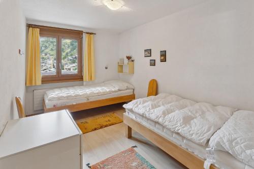 een woonkamer met 2 bedden en een raam bij Mountain whisper-4 pers. in Zermatt