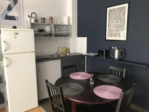 a kitchen with a table with chairs and a refrigerator at Perfect Family-friendly midtown APT+French balcony in Budapest