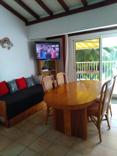 ein Wohnzimmer mit Tisch und Couch in der Unterkunft Ti Ecrin in Les Trois-Îlets