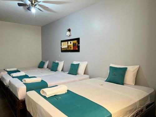 dwa łóżka siedzące obok siebie w pokoju w obiekcie Hotel Redinson w mieście Piura