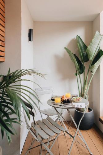 a table with a plate of food and a plant at Room Mate Oliveira - City Centre, Valencia in Valencia