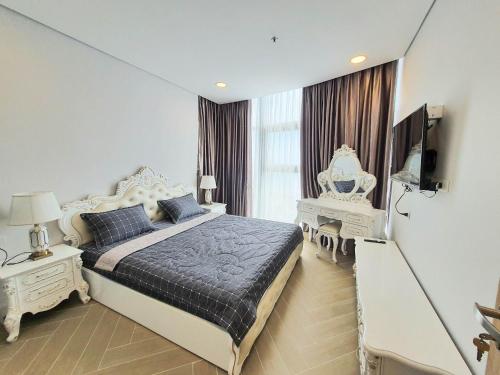 a bedroom with a bed and a television in it at Aria Resort- Căn hộ nghỉ dưỡng tầng 8 hướng biển, hồ bơi sát cạnh bãi tắm riêng (miễn phí) in Xa Thang Nhut
