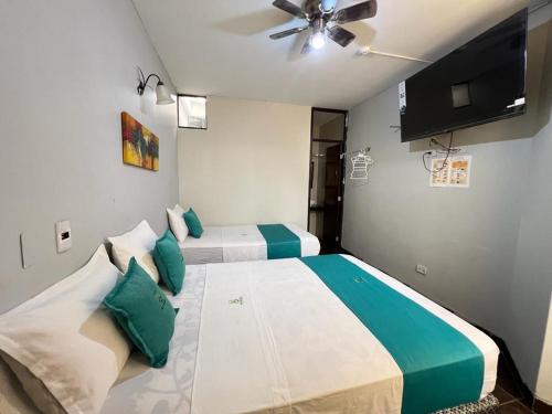 1 dormitorio con 2 camas y ventilador de techo en Hotel Redinson en Piura