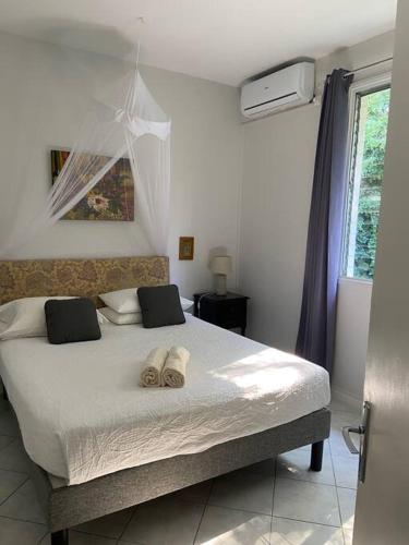 a bedroom with a bed with two towels on it at Villa "The Pretty Mermaid", pool and stunning views 5 min from beach in Deshaies