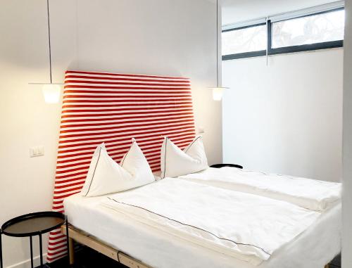 a bedroom with a bed with a red and white headboard at Maison Blue con Patio in Fregene