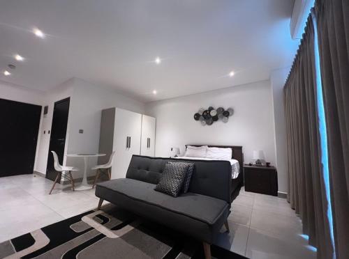 ein Wohnzimmer mit einem Sofa und einem Bett in der Unterkunft The signature premium studio (2) in Accra