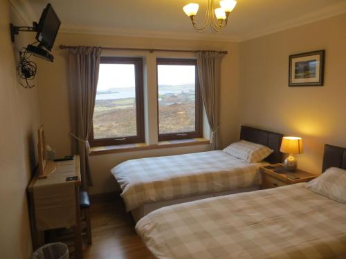 ein Hotelzimmer mit zwei Betten und einem Fenster in der Unterkunft Hill Cottage in Kensaleyre