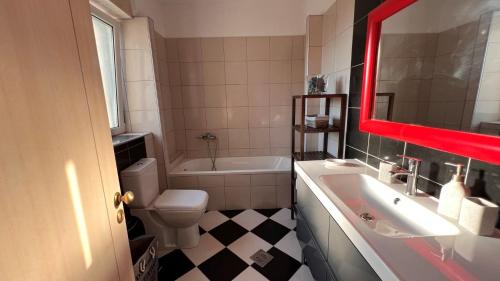 a bathroom with a tub and a sink and a toilet at Splendid Gouvia Villa 3 Bedrooms Villa Yiarios Private Playground in Pouládes