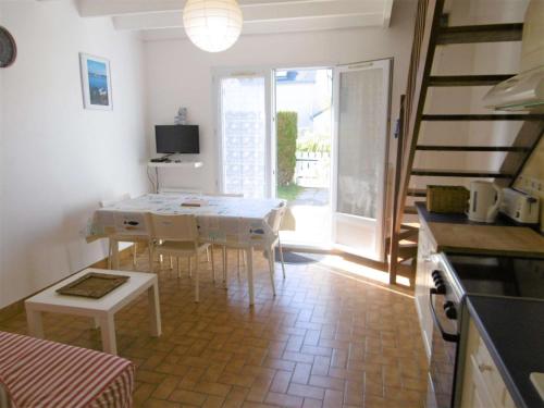 une cuisine et une salle à manger avec une table et des chaises dans l'établissement Maisonnette 3 pièces 4-5 personnes proche de l'océan - WIFI - Lenaig, à Sarzeau