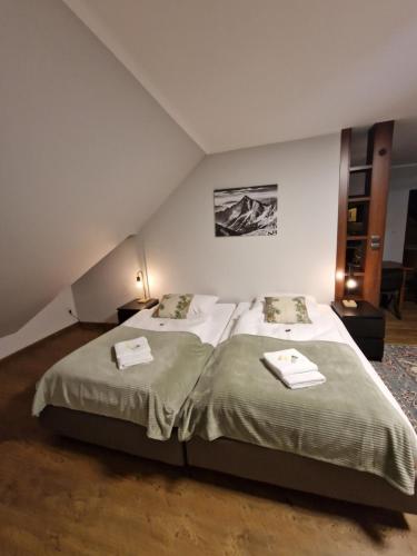 a bedroom with two beds with towels on them at Apartamenty Monti in Bukowina Tatrzańska