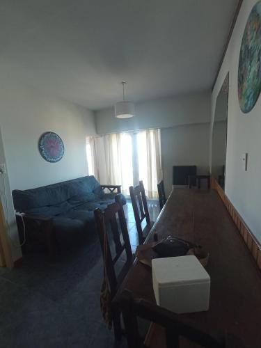 a living room with a table and a couch at Departamento frente al mar 3 ambientes Playas de Surf in Mar del Plata