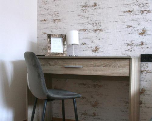a desk with a chair and a lamp on it at The Manhattan A Boutique Hotel By American Ease in Gravenwerth