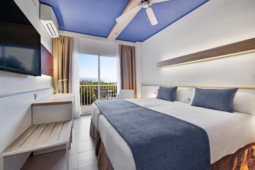 ein Schlafzimmer mit einem großen Bett mit blauer Decke in der Unterkunft Pabisa Sofia in Playa de Palma