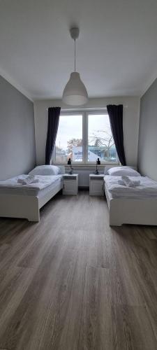 ブレーメンにあるZweibettzimmer "Grau" in zentraler Lageのベッドが2つと大きな窓がある寝室