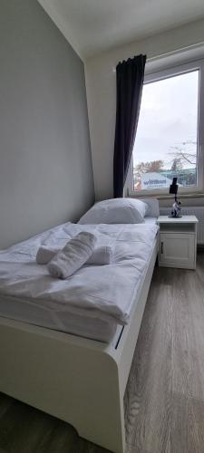 a large white bed in a room with a window at Zweibettzimmer "Grau" in zentraler Lage in Bremen