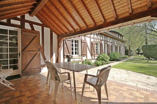 a wooden table and chairs on a patio at La Vallée in Hébécourt