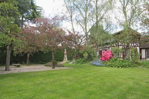 a house with a garden with pink flowers in the yard at La Vallée in Hébécourt