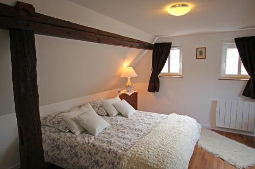Un dormitorio con una gran cama de madera con almohadas en Gîte Le Sarment, en Donnenheim