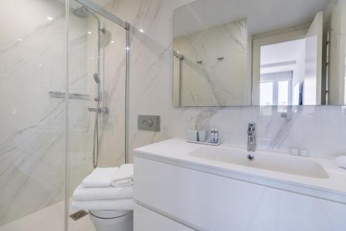 a white bathroom with a sink and a shower at Apartamento Plaza Colon Colon II in Madrid