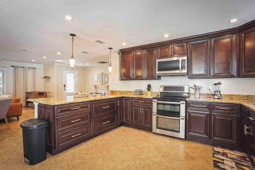 a large kitchen with wooden cabinets and stainless steel appliances at Heated Pool in Private House w/ Fire Pit in Seffner