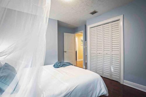 a bedroom with a white bed and a white closet at Heated Pool in Private House w/ Fire Pit in Seffner